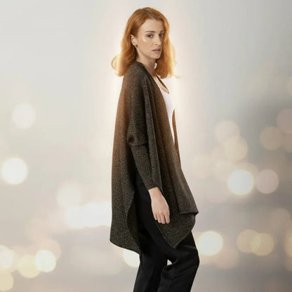 Chal Aurora para mujer en tejido de punto negro con destellos dorados de lurex y mangas integradas. Ligero, suave y elegante. Talla única. Hecho en Colombia. Ideal para fiestas de fin de año.