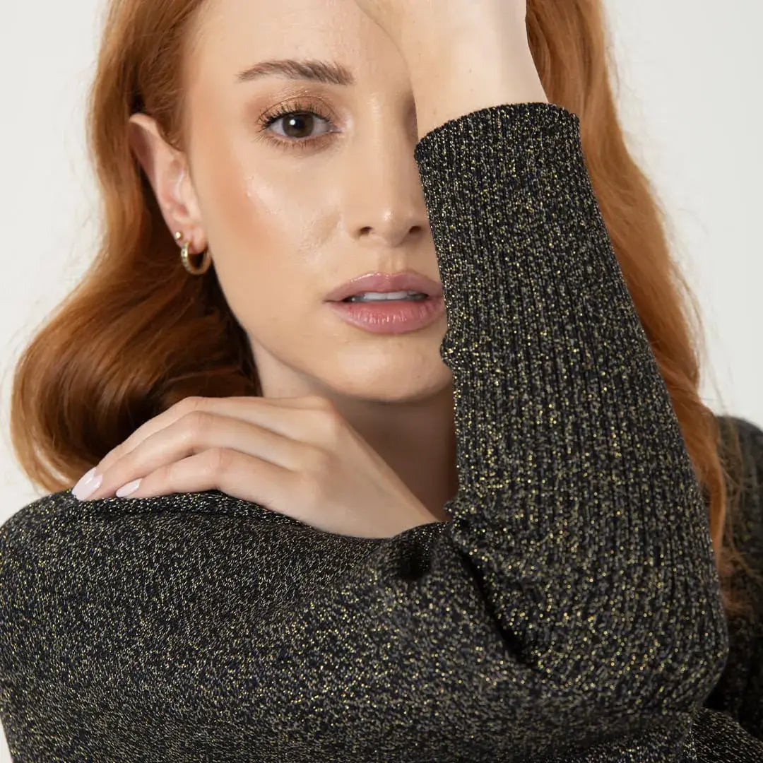 Chal Aurora para mujer en tejido de punto negro con destellos dorados de lurex y mangas integradas. Ligero, suave y elegante. Talla única. Hecho en Colombia. Ideal para fiestas de fin de año.