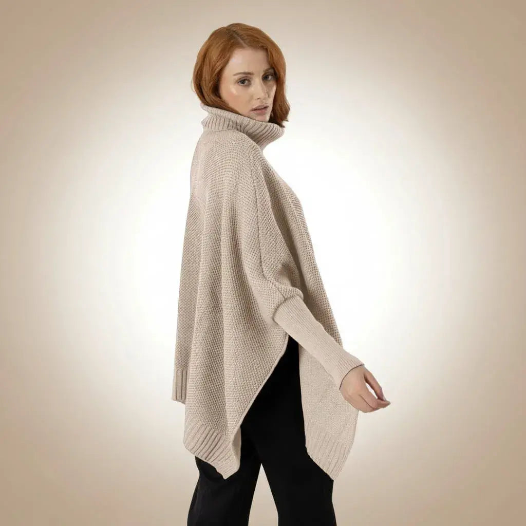 Ruana Sofía para mujer en acrílico, suave, cálida y liviana. Cuello alto en rib, mangas largas con puños ajustados y silueta oversize. Color arena, talla única. Hecha en Colombia.