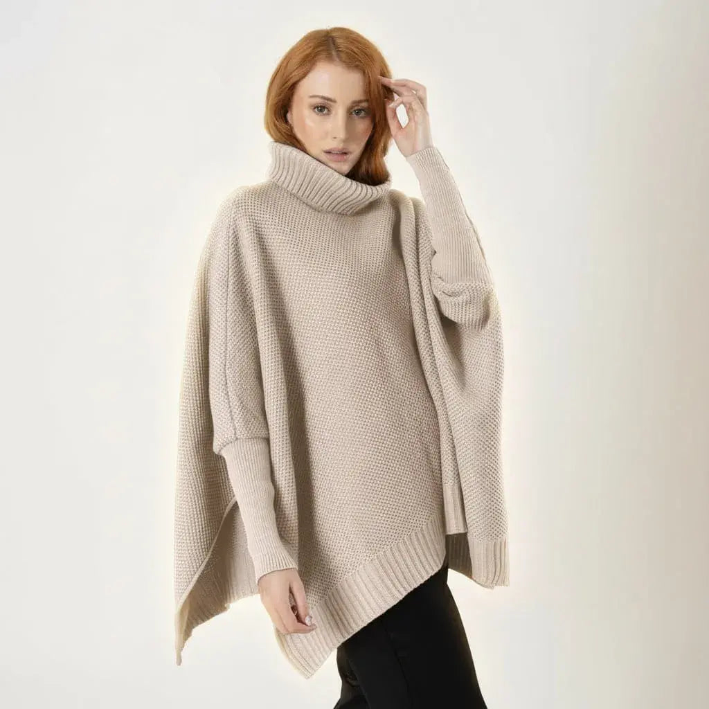 Ruana Sofía para mujer en acrílico, suave, cálida y liviana. Cuello alto en rib, mangas largas con puños ajustados y silueta oversize. Color arena, talla única. Hecha en Colombia.