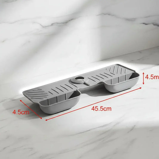 Tapete escurridor para grifo de lavaplatos con drenaje y compartimentos para esponja y jabón. Evita el agua acumulada alrededor de la llave, es extensible y se instala sin herramientas. Ideal para la cocina, el baño y el lavadero.